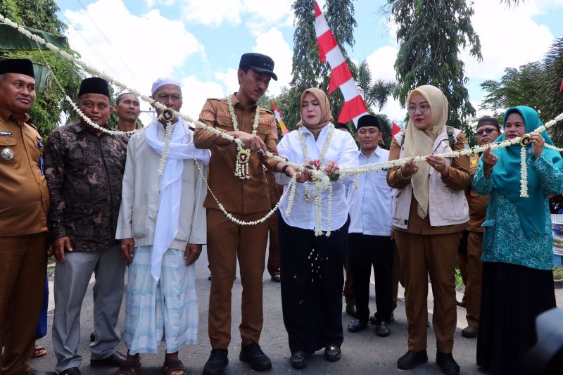Bupati Banjar Saidi Mansyur didampingi Ketua TP PKK Nurgita Tiyas memotong untaian bunga menandai peresmian peningkatan/pemeliharaan ruas jalan Handil Jawa - Jambu Burung di Kecamatan Beruntung Baru, Selasa (10/9/2024).