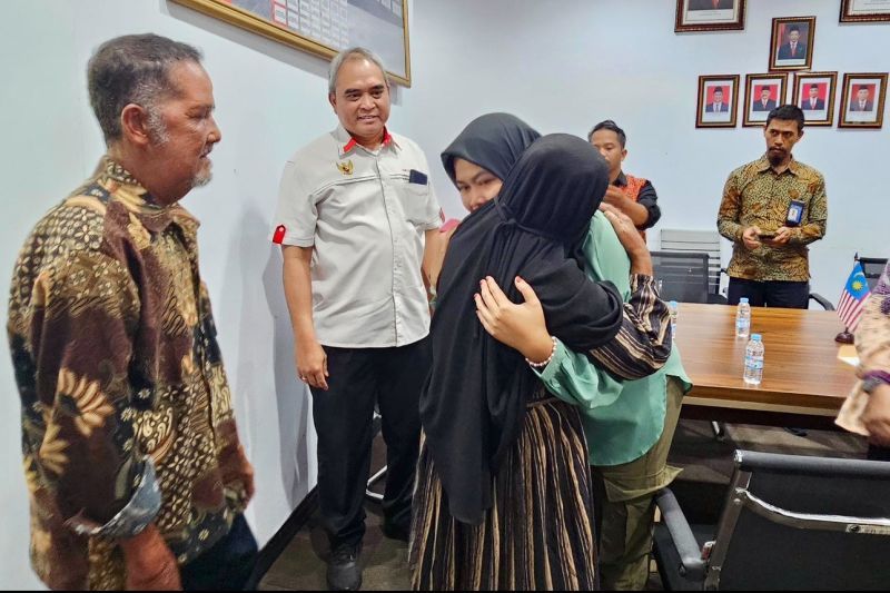 Setelah 18 tahun berpisah, korban TPPO, Marlia (kanan) akhirnya memeluk ibunya di hadapan ayahnya (kiri) dan Konsul Jenderal RI Kuching, Raden Sigit Witjaksono (kedua kiri), dalam proses pemulangannya di PLBN Aruk, Sambas, Kalimantan Barat, pada Jumat (25/10/2024).