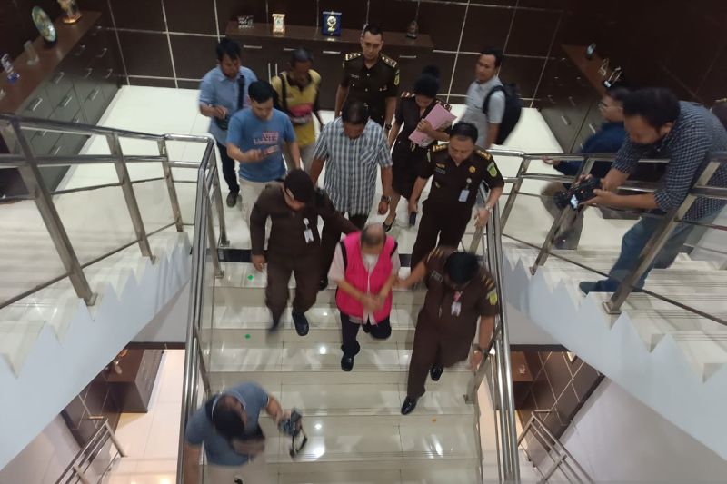 Petugas Kejaksaan Tinggi Pontianak mengawal TAM, anggota DPRD Kalbar yang baru saja ditetapkan sebagai tersangka dalam kasus mark-up pengadaan tanah untuk pembangunan bank daerah (ANTARA/Rendra Oxtora).