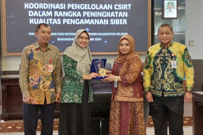 Kepala Bidang Persandian dan Keamanan Informasi Diskominfo Provinsi Kalsel, Sucilianita Akbar (kedua kiri), memberikan plakat kepada Ketua Keamanan TIK Pusdatin BPOM RI, Wina Budiwardani, di Banjarbaru, Jumat (25/10/2024).